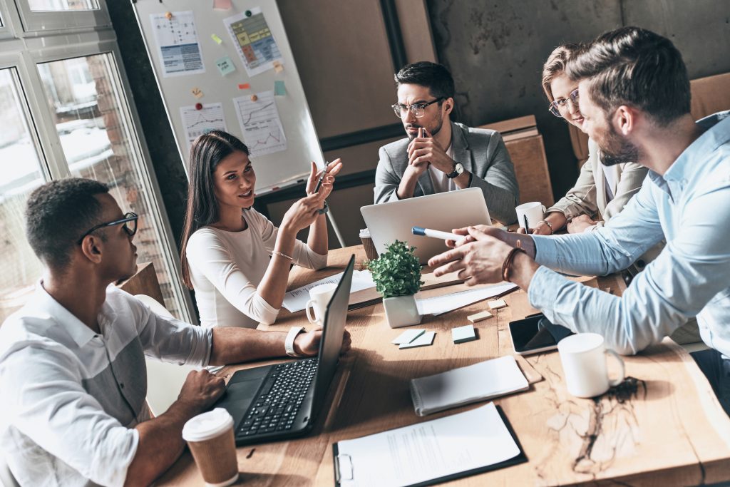 Team at work. Top view of young modern people in smart casual wear discussing business while working in the creative office