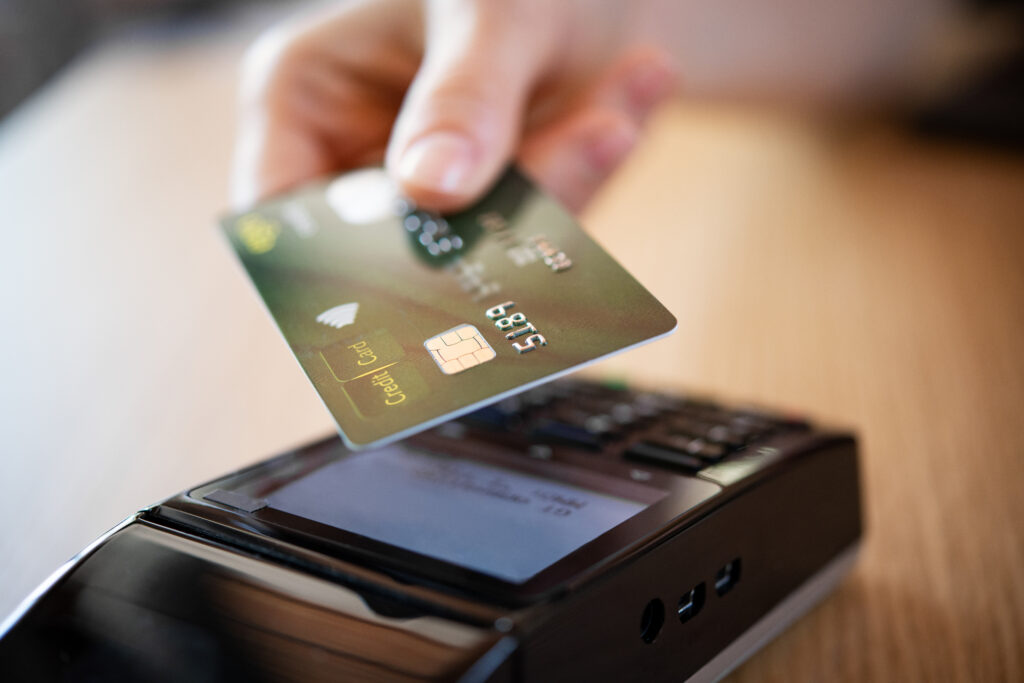 Credit card held up to payment terminal for a contactless payment