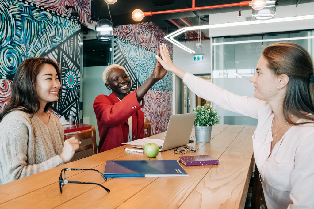 Coworkers high five over conference table