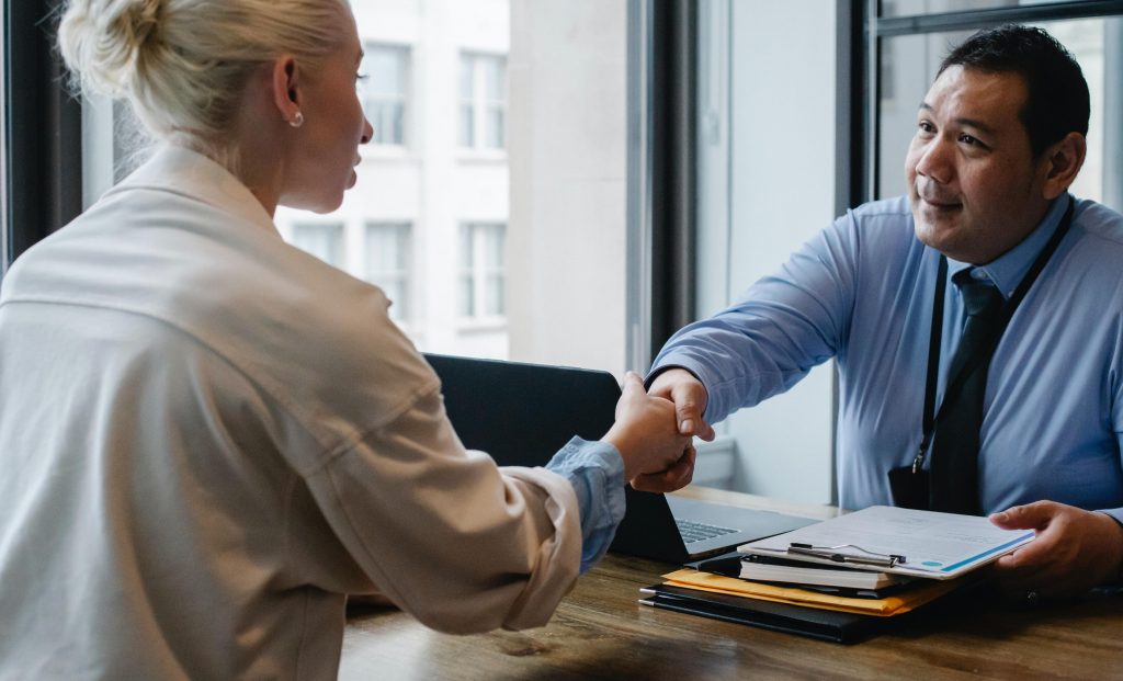 Man and woman shake hands in job interview